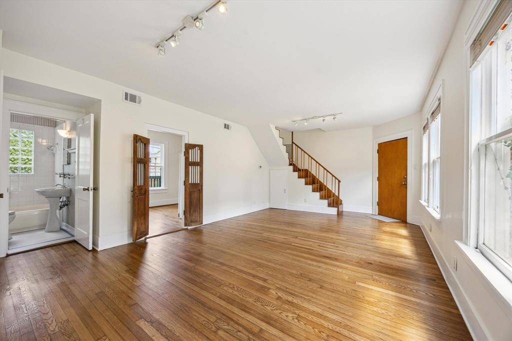 Living room with bathroom, entry to kitchen through antique Afghan doors, front door and stairs to 2nd floor.