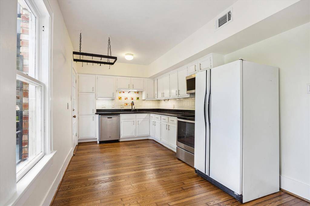 Spacious kitchen with granite countertops, Whirlpool stove, and Maytag dishwasher. The home comes with a 1-year home warranty.