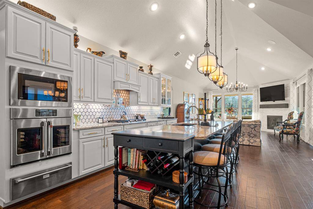 Experience culinary bliss in this custom Kitchen, featuring seeded glass cabinets, soft-close drawers, an electric Warming Drawer, GE Cafe French Door Wall Oven that offers many features including convention and air frying.