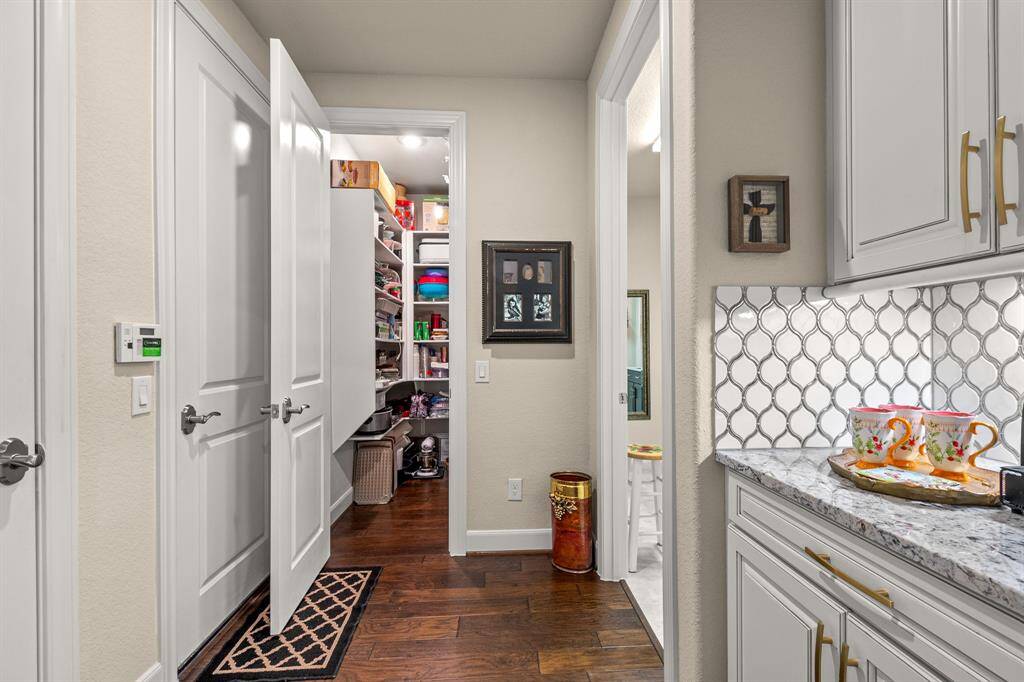 You'll love this beautifully organized Butler's pantry with abundant storage that is spacious and well-lit, offering plenty of storage for household items and small appliances.