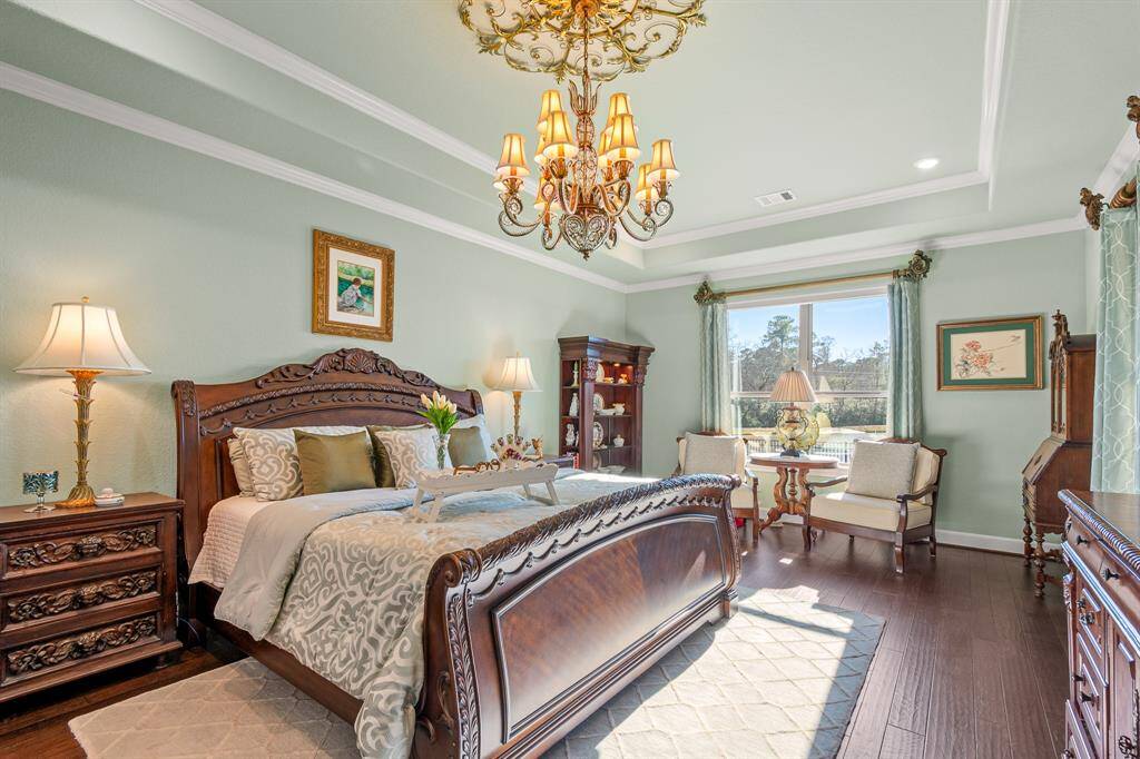 Experience elegance in this Primary Bedroom with a large window offering scenic views of the community Lake and abundant natural light. Features remote controlled shades and hardwood floors. Decorative molding adds sophistication.