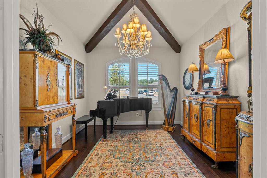 This elegant Home Office/Study/Music Room that boasts of a vaulted ceiling with exposed beams, offering a sophisticated ambiance. Plantation shutters offer privacy and natural light, enhancing high end finishes.