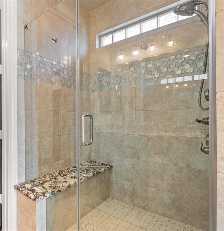 Extra Large Primary Shower that has multiple massage jets with designer accent tile and sleek walk in access.