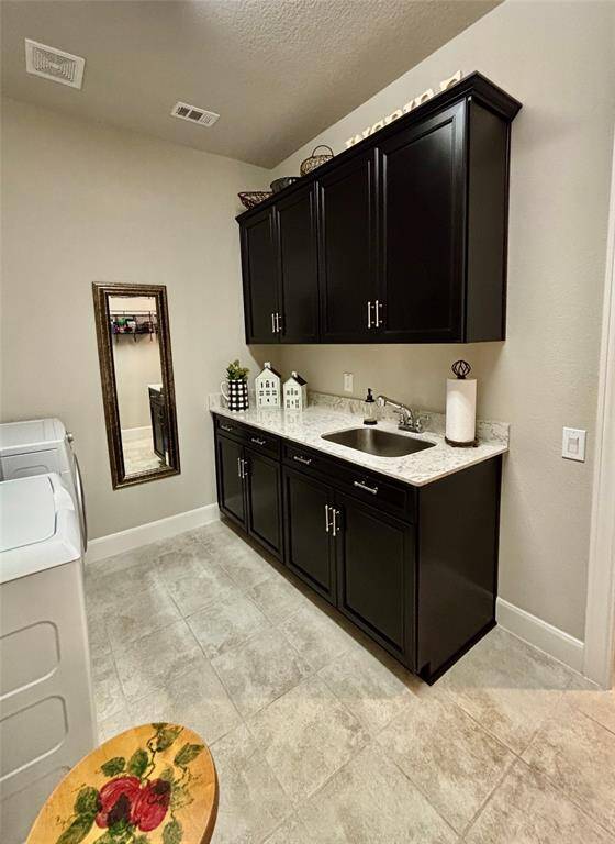 Bright and functional Utility Room supporting a washer, dryer, counter sink, and ample shelving. Conveniently connected to an the Primary Closet area for seamless access.