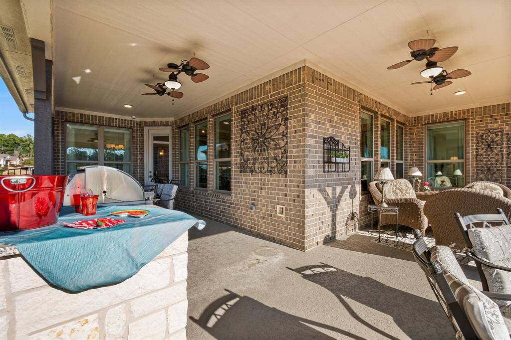 Enjoy your spacious, covered patio with ceiling fans, and comfortable outdoor seating. Ideal for entertaining, which includes an elegant stone outdoor Kitchen with a built-in grill and refrigerator, providing a cozy and stylish outdoor living space.