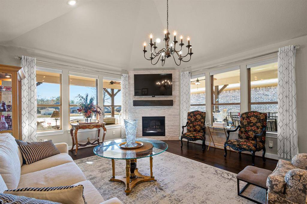 Experience the charm of this spacious Living room with vaulted ceilings, large windows, and a cozy Fireplace that creates a warm and inviting atmosphere.