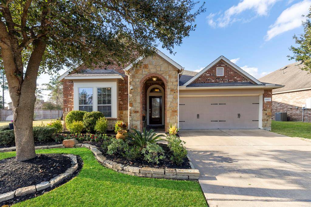 Charming single-story home with a stone and brick facade. Features a spacious two-car garage, well-manicured front yard with lush greenery, and a welcoming arched entryway. Ideal for comfortable family living.