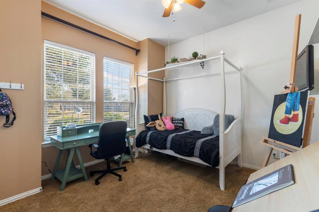 Cozy bedroom with large windows letting in natural light.