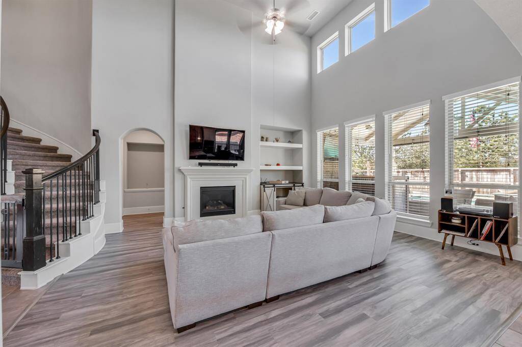 Family room is so light and airy, open to kitchen and your beautiful backyard.  Sit back and enjoy the fireplace on cold nights.  Look at that custom built in shelving.