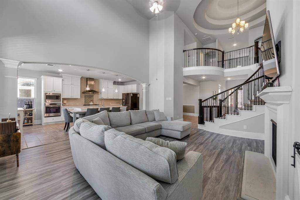 Beautiful open living space with tall ceilings, lots of natural light and a great view of elegant staircase.