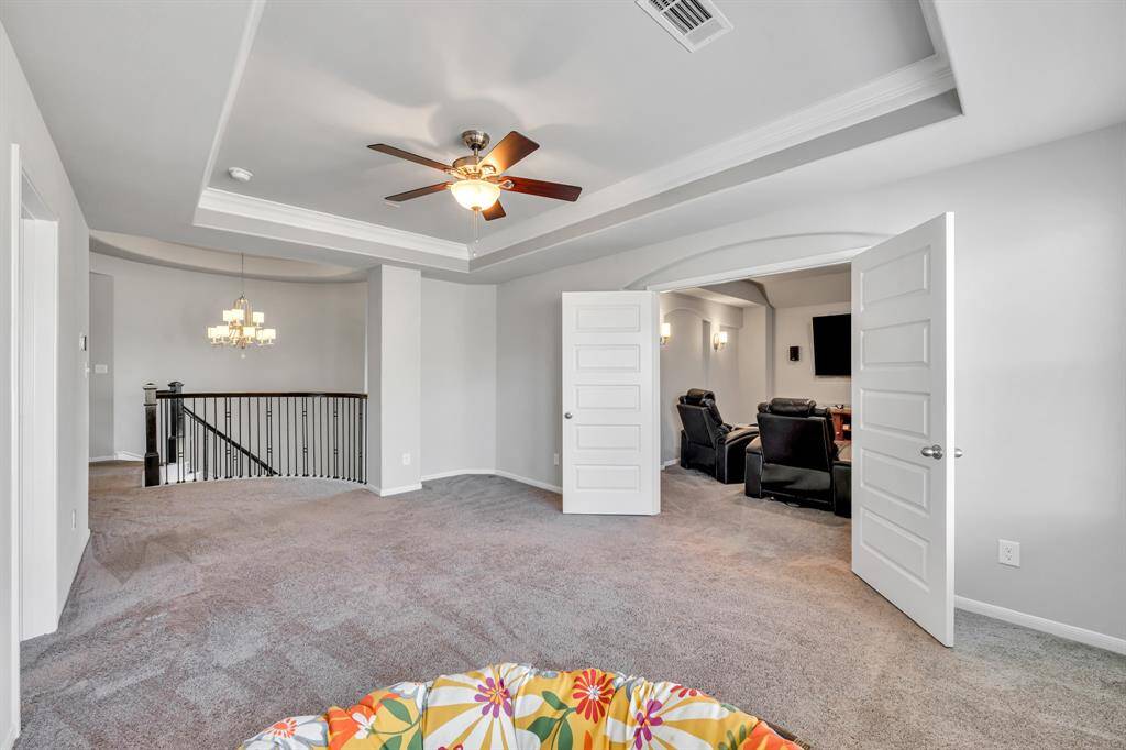 Bonus room ready for you to make it your own space with tray ceilings and ceiling fan, open and welcoming.