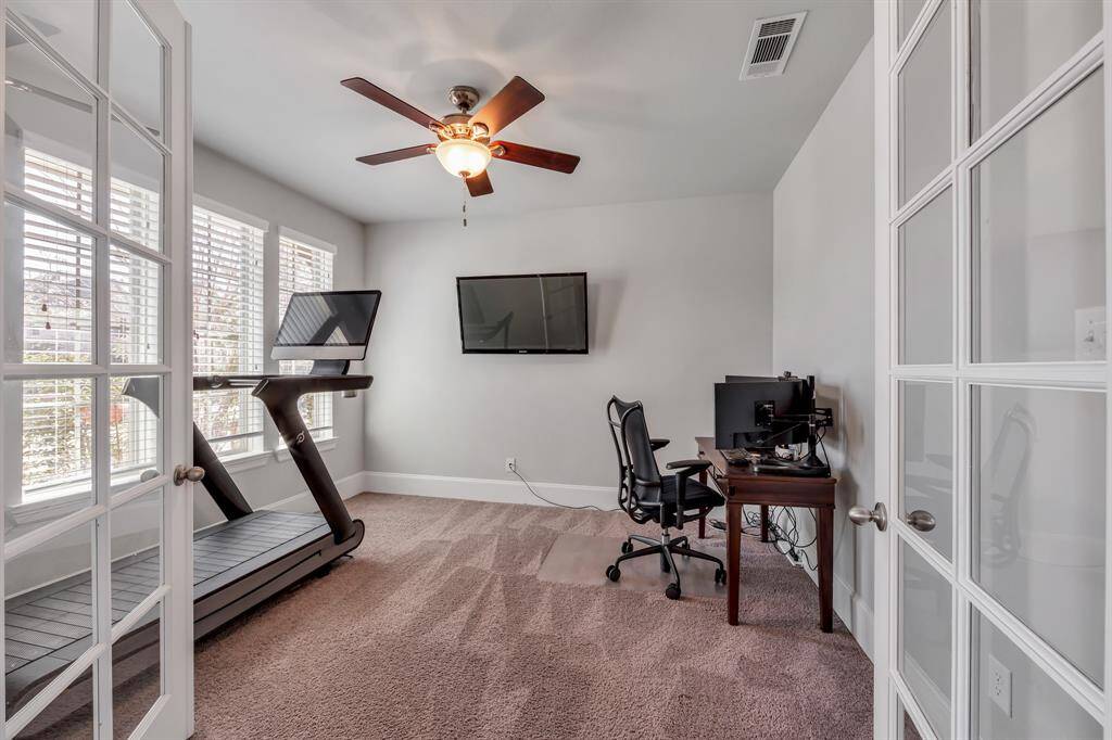 The office/ study featuring French doors, ceiling fan, large windows with custom blinds.  A great space for all uses.