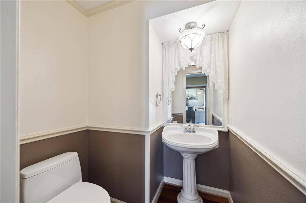 This amazing kitchen includes modern stainless steel appliances, a central gas stove with an overhead hood, and abundant natural light from large windows with plantation shutters. Perfect for culinary enthusiasts and entertaining.