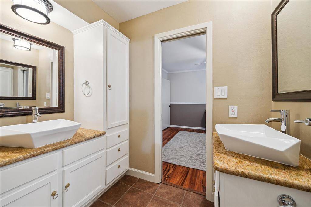 In-house laundry room with elegant cream cabinetry, ample storage, a large sink, and tiled flooring, creating a clean and functional environment.  Plus room for a refrigerator or deep freezer!