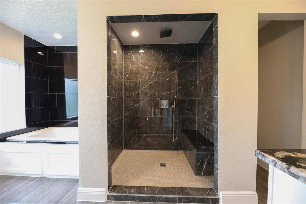 Primary Bath offers walk-in shower w/ rain fixture & separate soak tub.