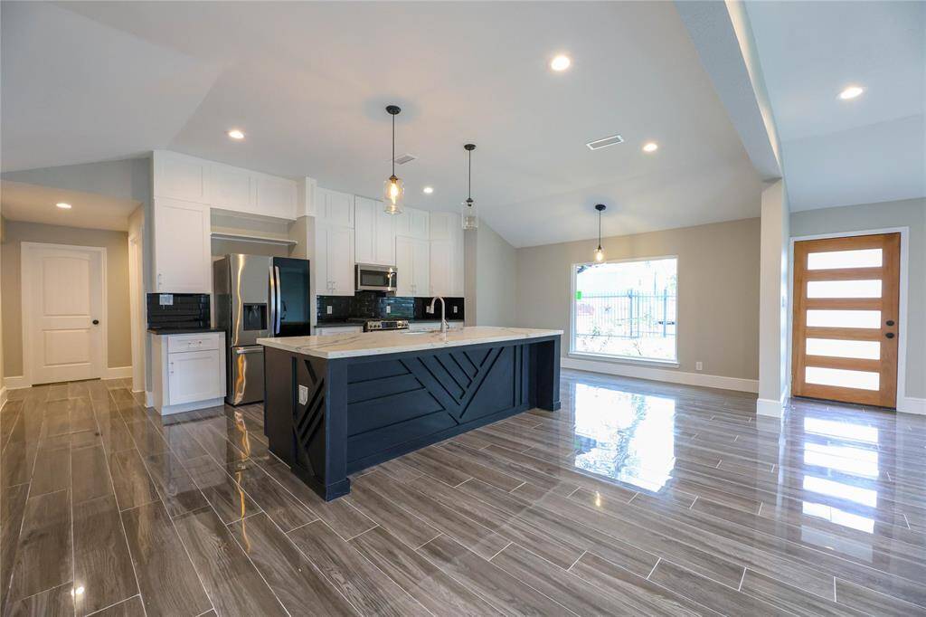 The Kitchen offers a large quartz island, stainless steel appliances & breakfast area.