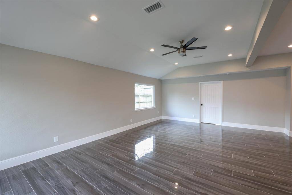 Family Room is wide open w/ tile throughout, LED puck lighting, large windows & ceiling fan.
