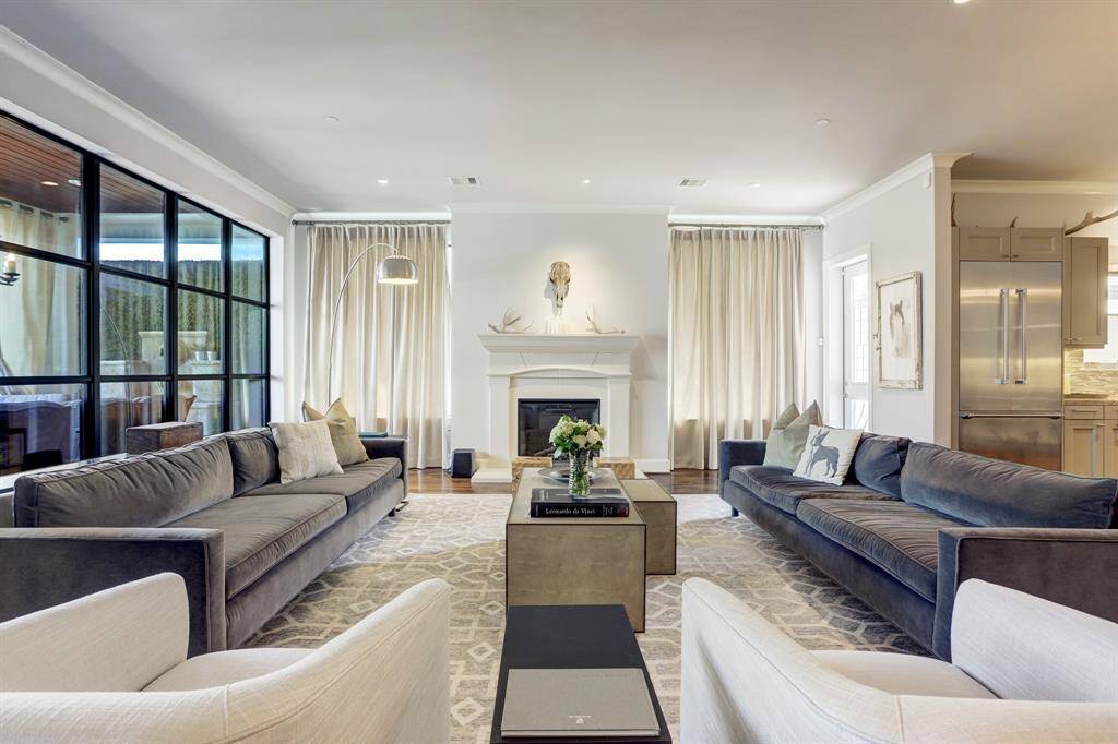 Spacious living room features hardwood floors, 10ft ceilings, fireplace and large windows that open to one of the three balconies.