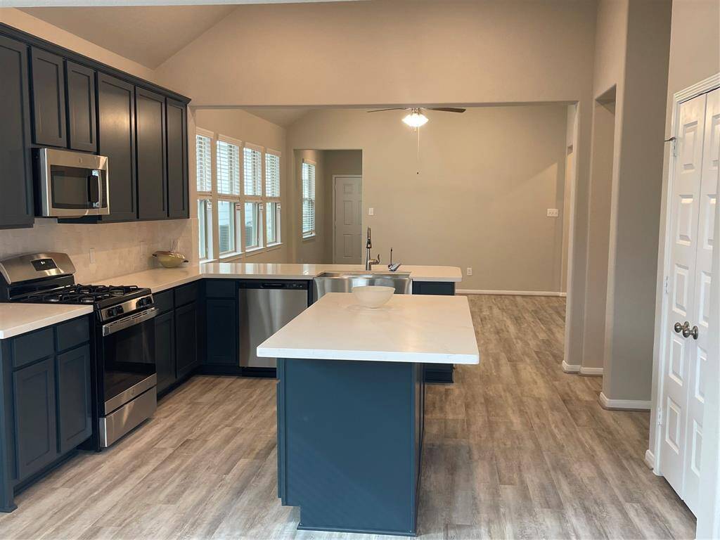 Island kitchen with blue cabinets and quartz countertops