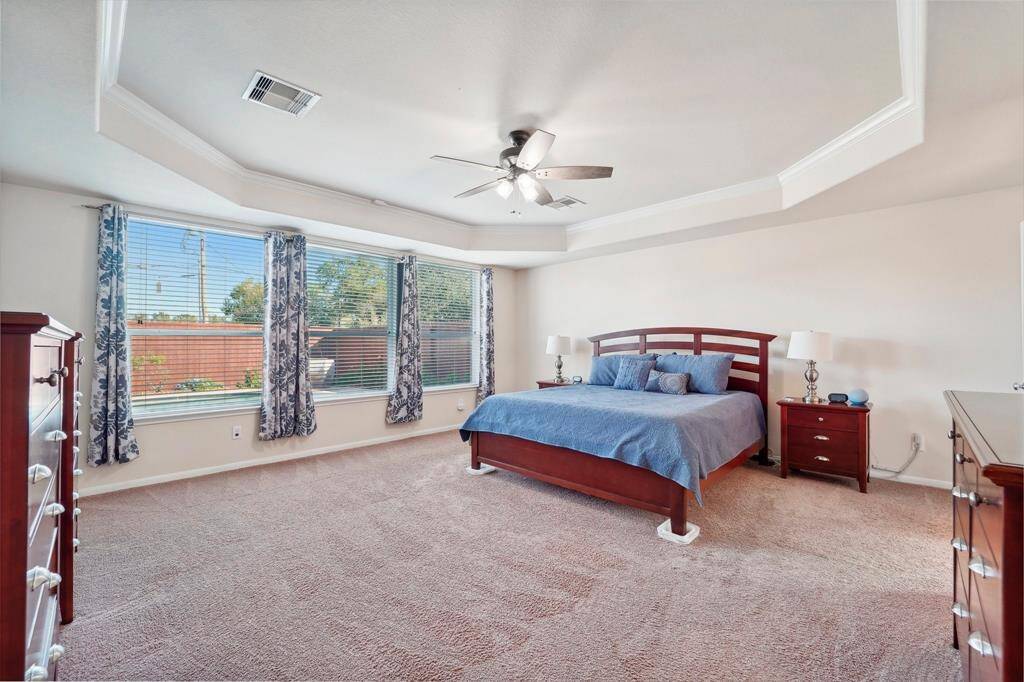 The primary bedroom overlooks the backyard oasis