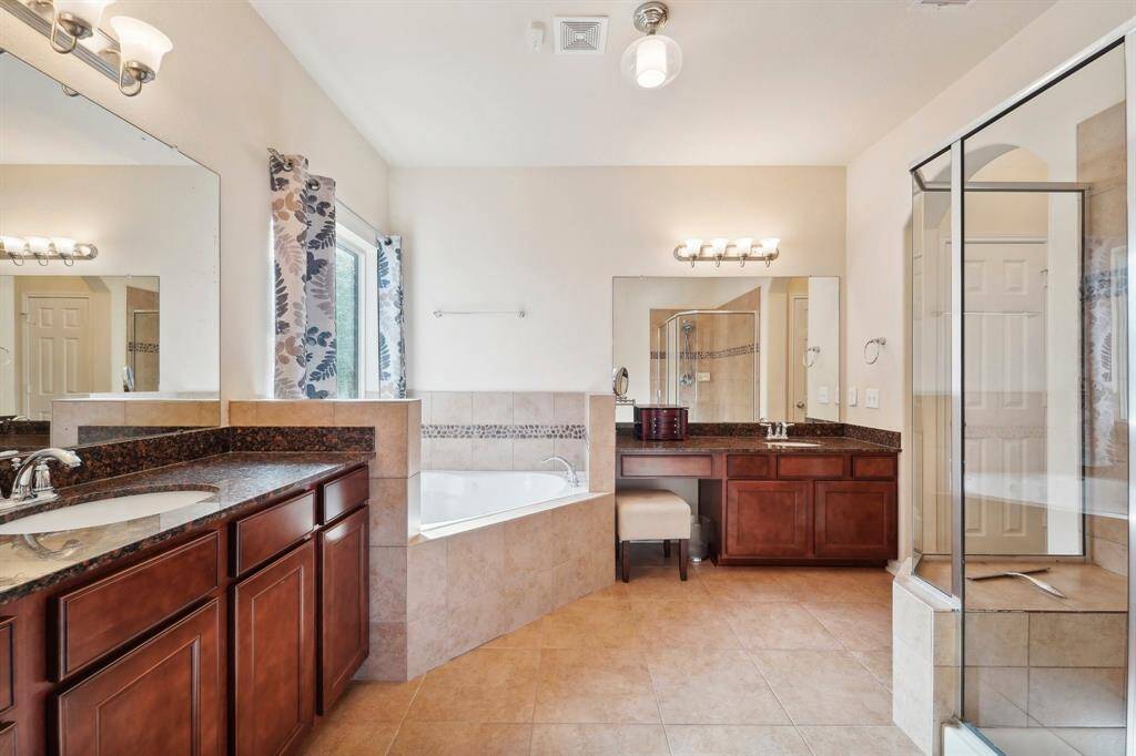 Primary en-suite bathroom features walk-in shower and separate tub