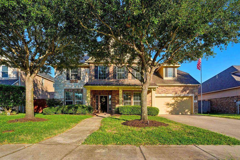 A well-manicured lawn and covered porch are inviting. This home has LED lighting on the soffits that are so pretty at night!