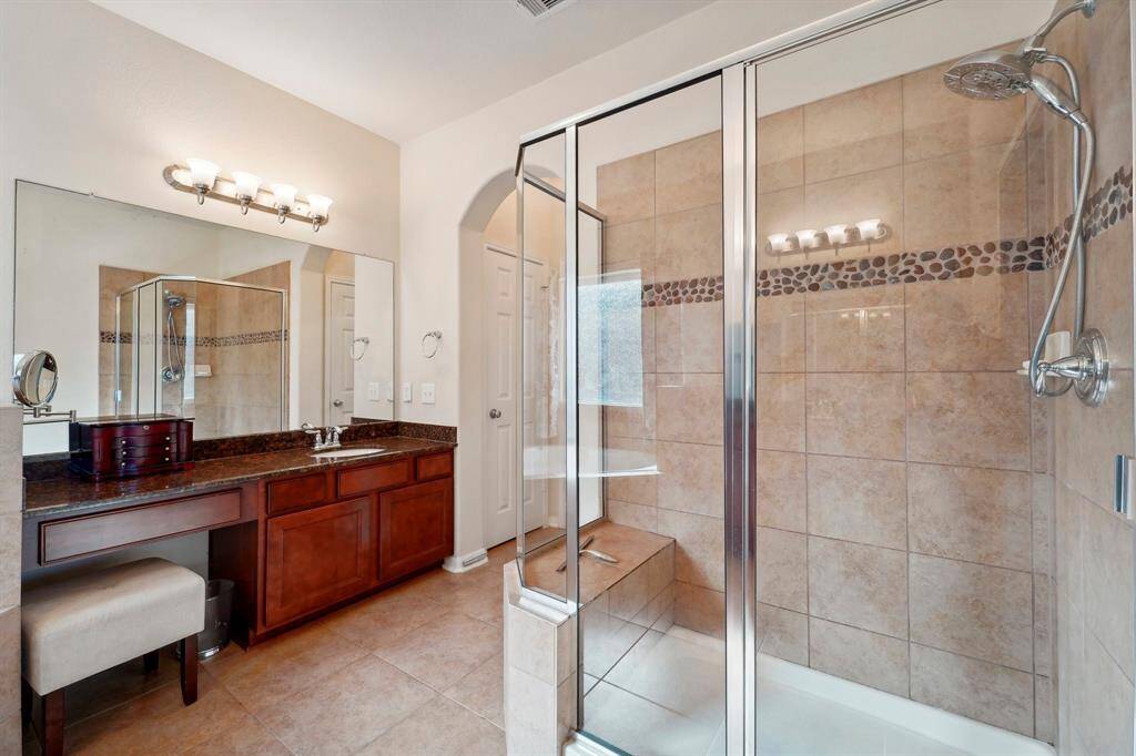 The oversized shower has a pretty tile inlay.