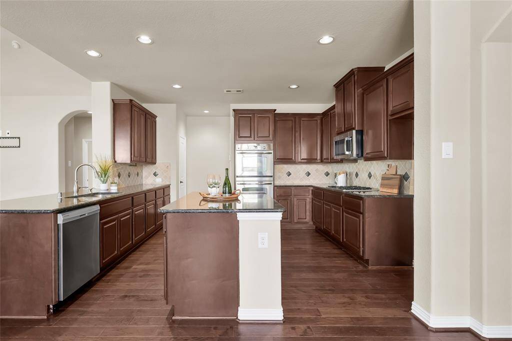 Features of this kitchen include a sizeable island, stainless steel appliances, and open to both the living and dining rooms.