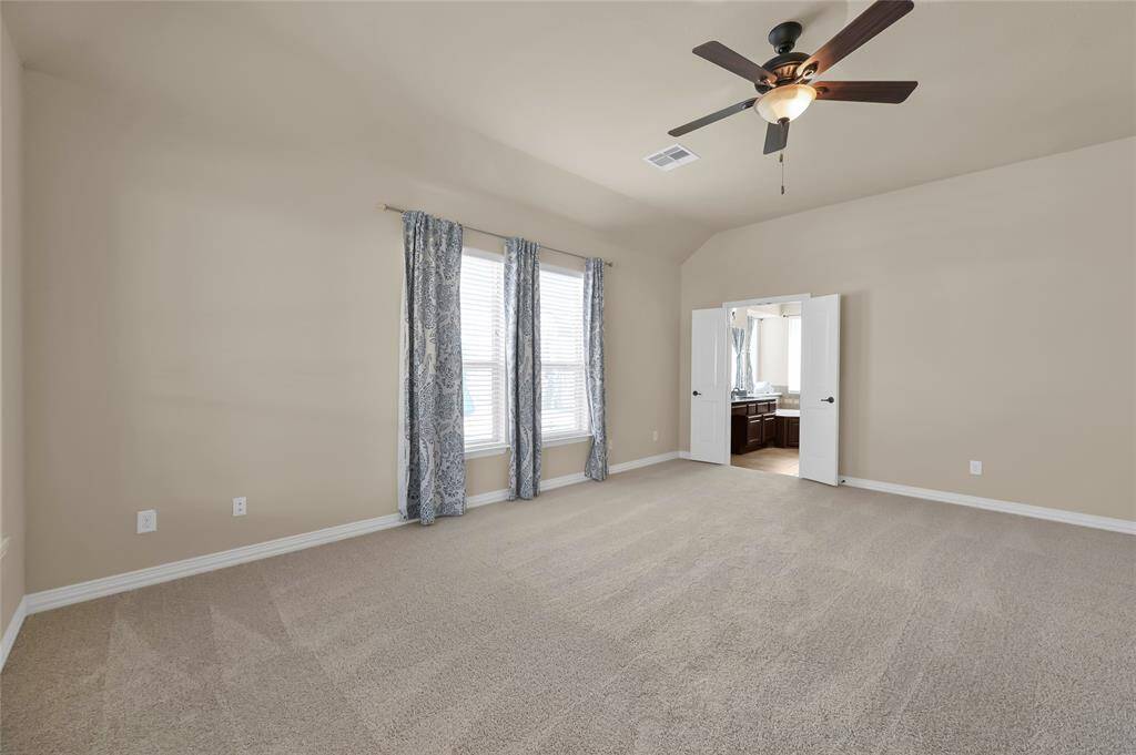 Relax in your primary bedroom, with soft carpets, and large windows