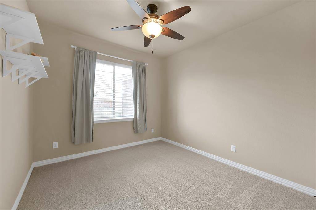 quaint secondary bedroom with built in shelving and ceiling fan