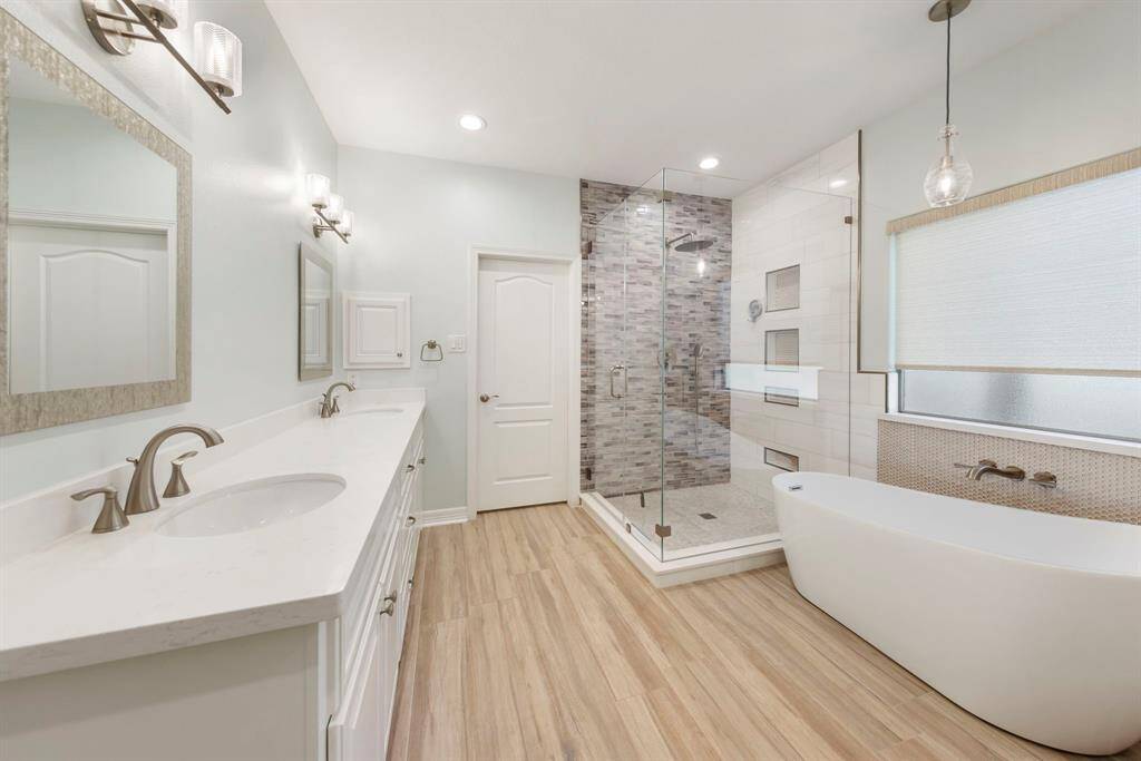 The luxurious primary bathroom showcases an oversized tile shower and a separate soaking tub, creating a serene retreat for relaxation and pampering.