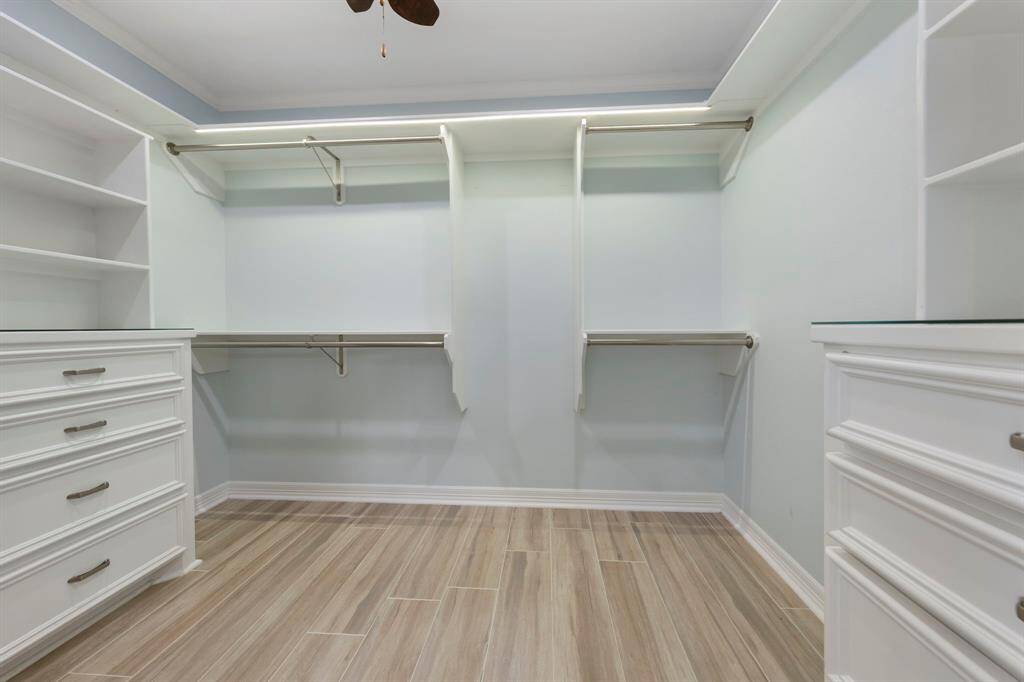 The second custom closet includes built-in shelving and organizers, providing smart storage solutions for all your wardrobe needs.