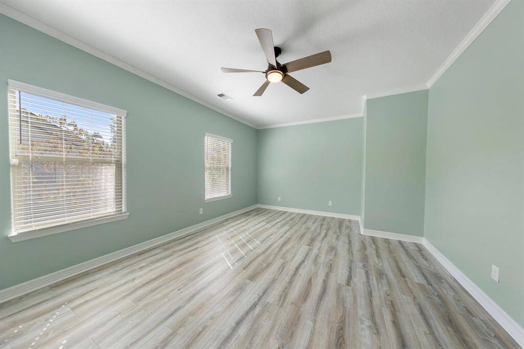 This spacious bedroom boasts fresh paint, a new ceiling fan, and luxury vinyl plank flooring.