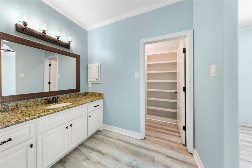 The Jack and Jill bathroom features separate vanities and a walk-in closet, offering both convenience and privacy for its users.