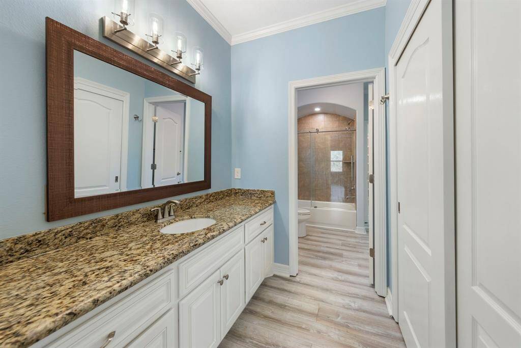 The Jack and Jill bathroom includes a shared shower/tub combo and toilet, along with personal granite vanities and individual closets.