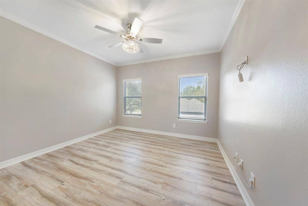 The third upstairs bedroom offers fresh paint, LVP flooring, a new ceiling fan, and bright windows, providing a cozy and inviting atmosphere.