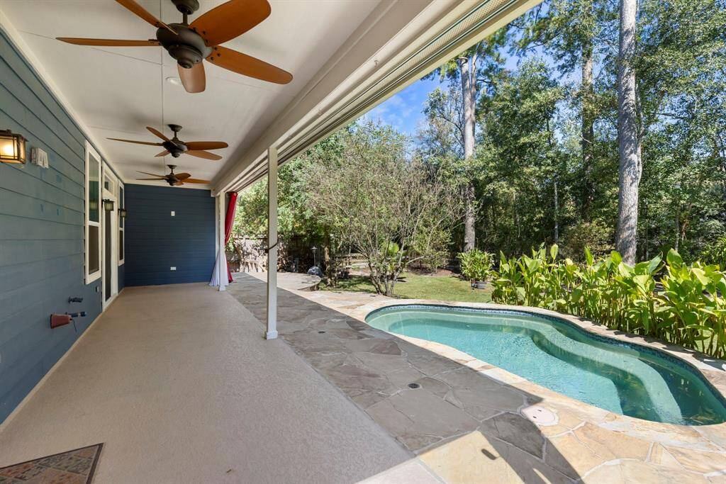 Step outside to the expansive covered patio, complete with ceiling fans, where you can relax and enjoy stunning views of the sparkling pool.