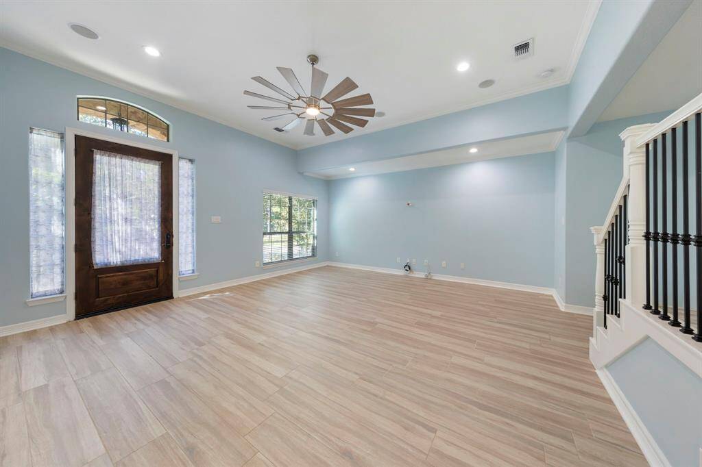 Open plan offers large living equipped with built-in surround sound speakers and features a sleek, new fan for added style and comfort and abundant light with windows on all sides!