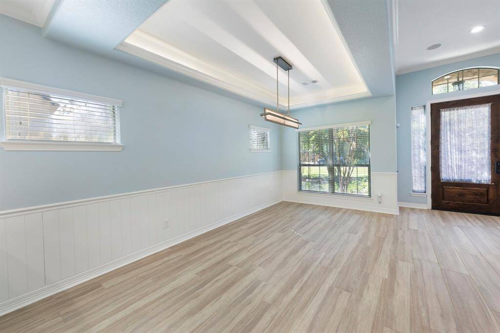 The dining room features an elegant tray ceiling and chair rail molding, adding a touch of traditional charm to the space.