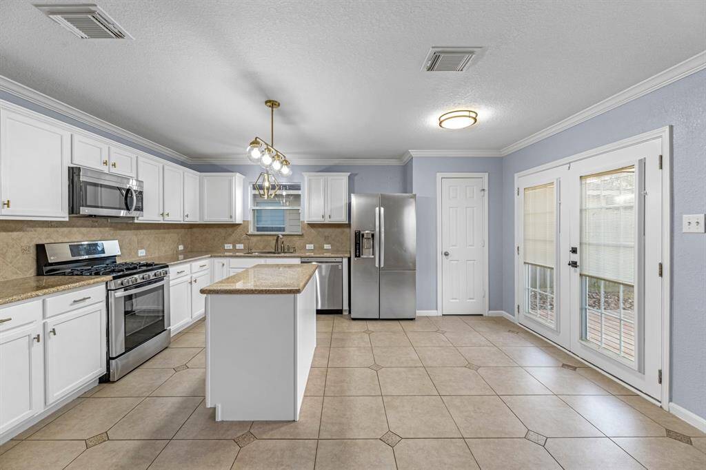 Updated Kitchen: Solid white cabinetry, granite countertops, stainless appliances.
