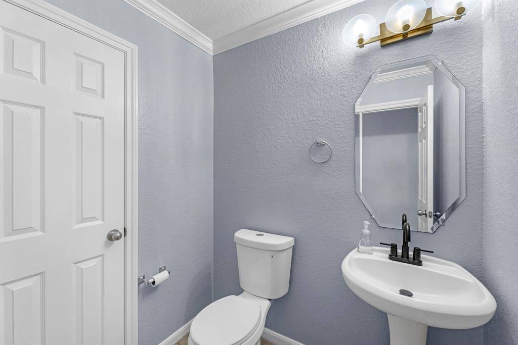 Powder Bath on first floor: pedestal sink, updated lighting, elongated toilet, updated fixtures, tile floors.