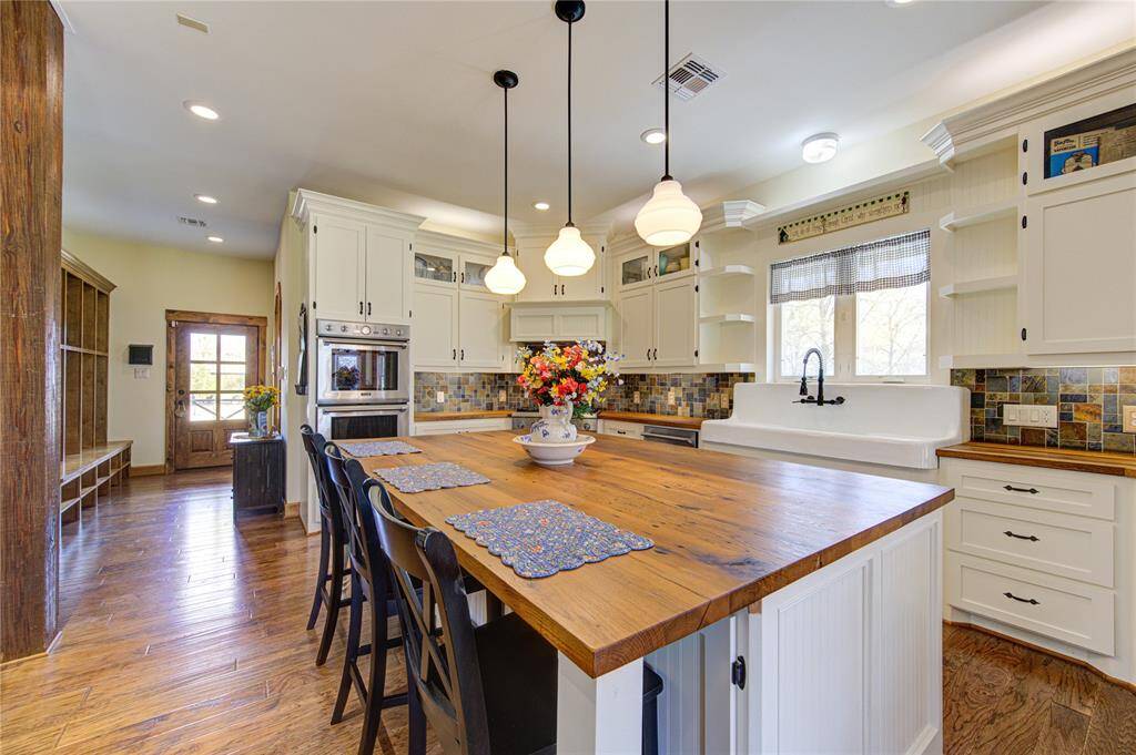 Large island with reclaimed white oak countertops. Island features a Face-grain finish.  Kitchen cabinets feature over and under lighting.