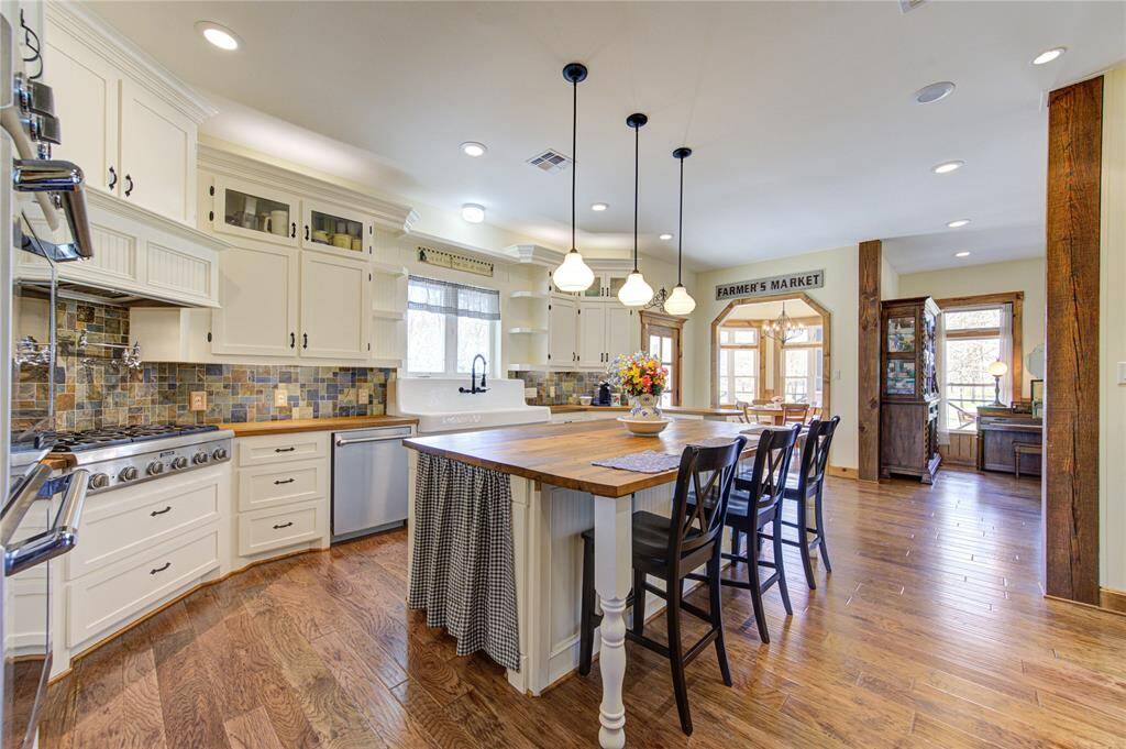 Countertops adjacent to the island boost an Edge-grain finish.  A cast iron enameled double drainboard farmhouse sink adds beauty and functionality.