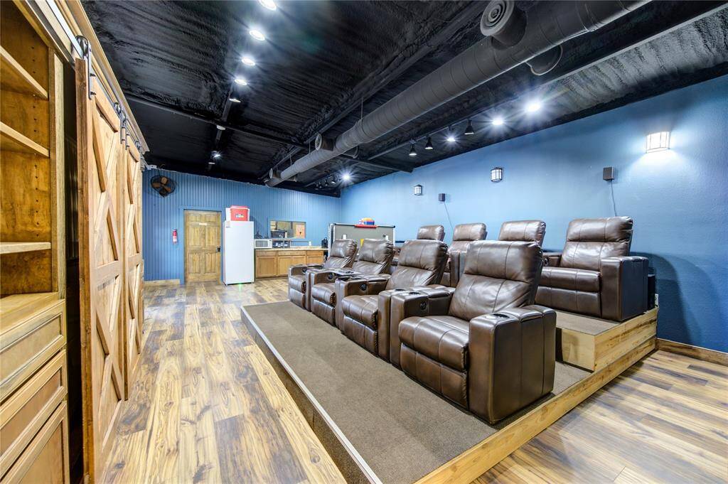 Media room includes built in storage and entertainment center with barn doors as well as stadium seating. The space also includes a kitchen, separate office and full bathroom.