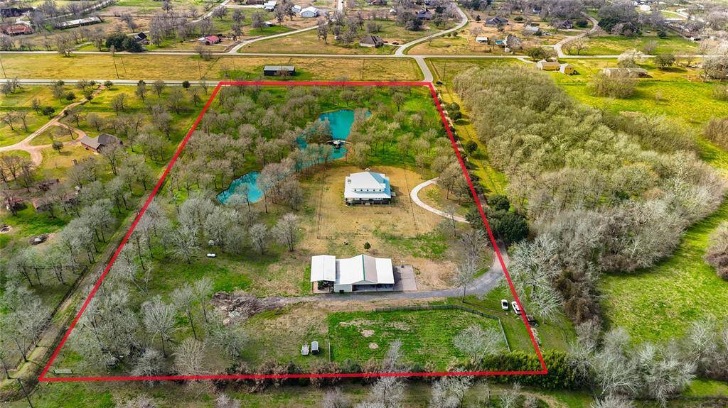 This spacious rural property outlined in red, featuring a charming house, lush greenery, and a scenic pond. The expansive land offers privacy and picturesque views, ideal for those seeking a tranquil country lifestyle.