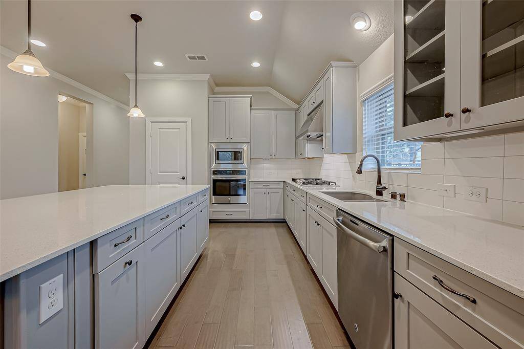 Glass front cabinets, stainless steel GE appliances.