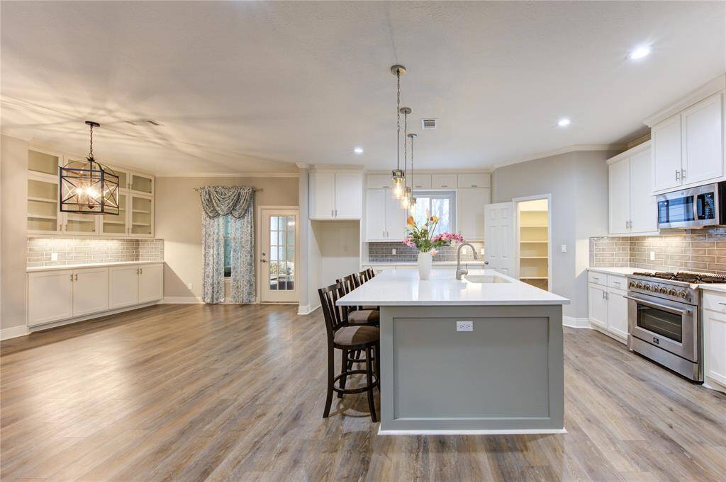 The huge gourmet kitchen is a chef’s dream, designed with both style and functionality in mind. At its heart lies a massive island, offering ample space for meal prep, casual dining, and lively gatherings.  The open layout seamlessly flows into the dining room, ensuring effortless entertaining.