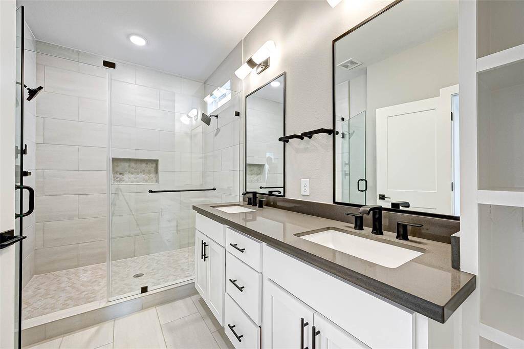 The 6x12 SF primary bath has quartz counters, double undermount sinks, custom Moen hardware, and a 4x6 SF frameless standing shower.