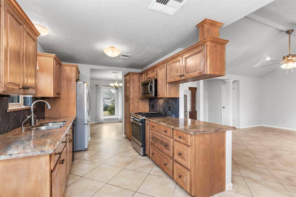 Lots of granite counter area, double sink, gas range with microwave above and pantry.