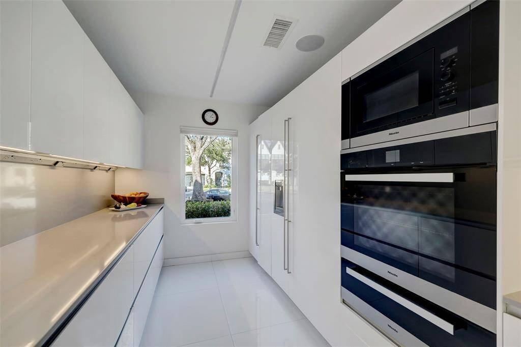 The Kitchen was designed by Snaidero using white lacquer cabinetry.  Notice the attention to detail: even the 48" Built-In Refrigerator, Dishwasher and Vent Hood have custom cabinet fronts for a modern look.
